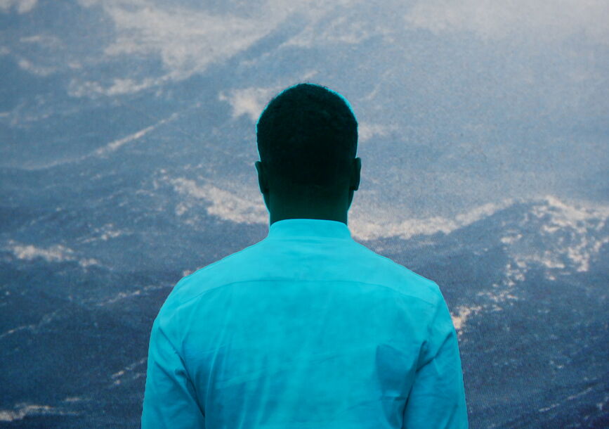 A person faces towards the mountains.