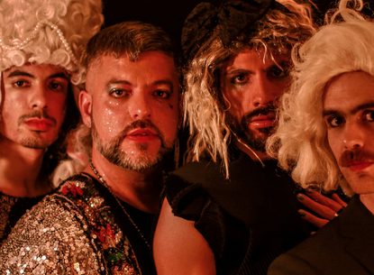 4 men dressed in drag staring at the camera together