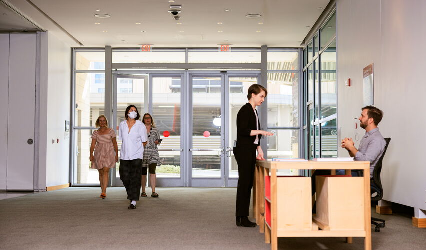 An attendant at a desk speaks to a visitor