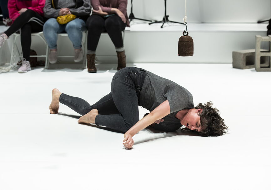 Faye Driscoll performing on a white floor.