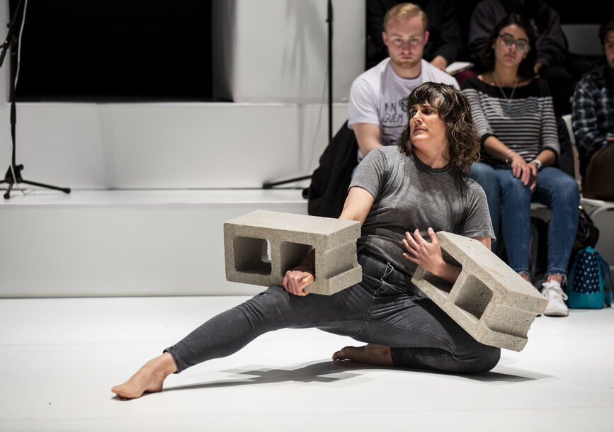 Faye Driscoll performs with two cement blocks.