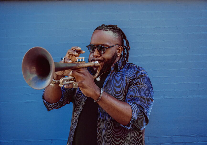 A man blowing into a trumpet.