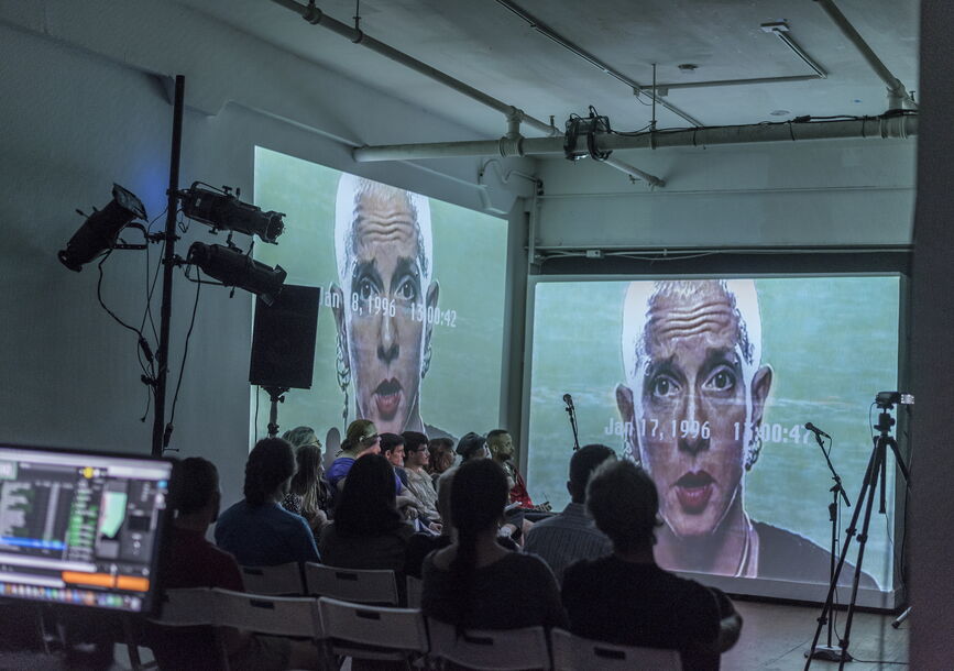 Audience watching a person on video screens 