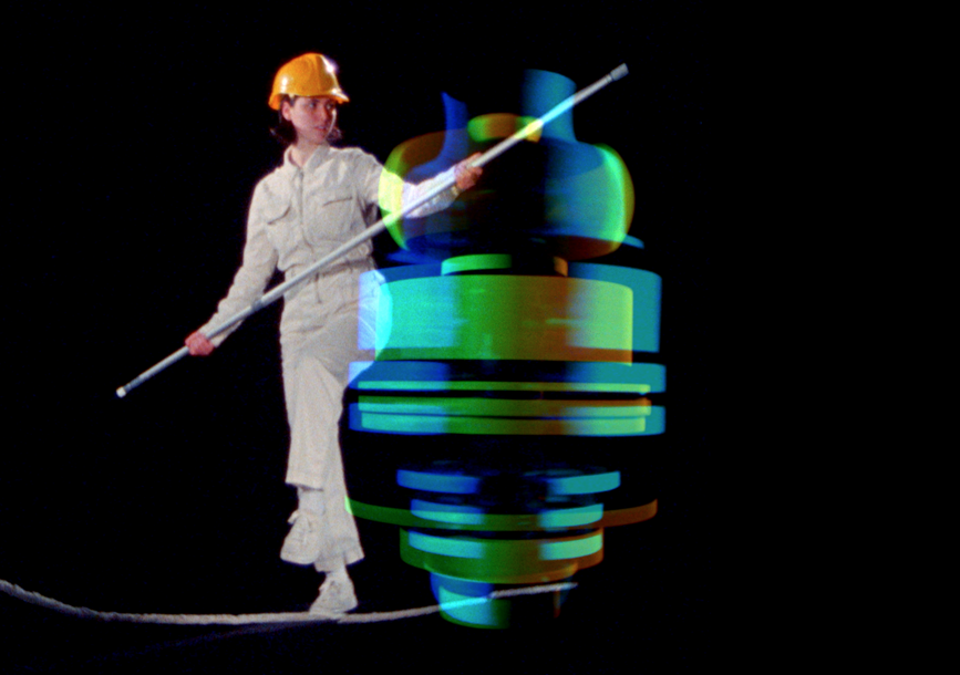 A woman with a hard hat walks a tight rope. 