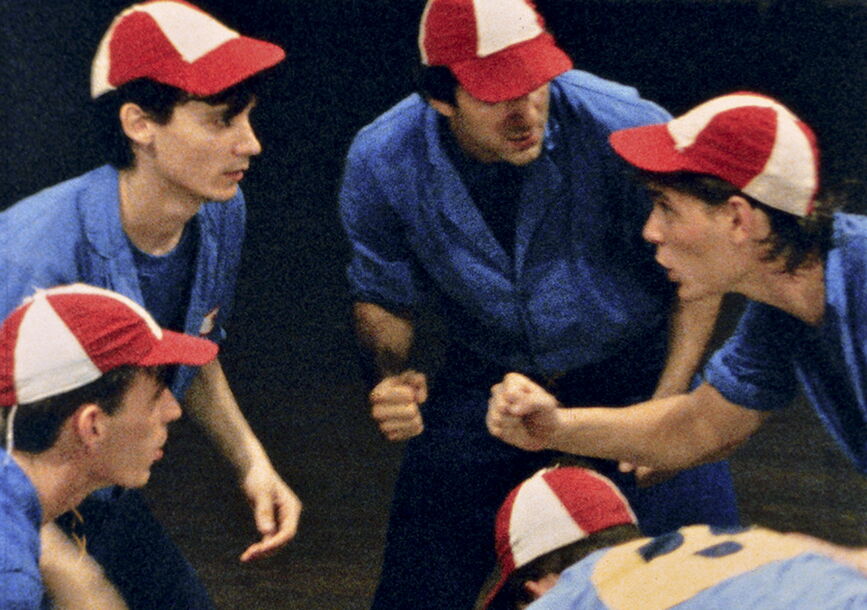 Four people with hats form a circle.