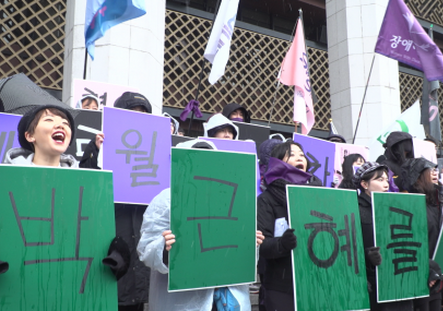 protestors holding green signs 