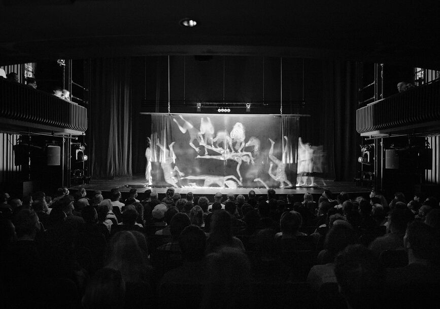 An audience watches a performance on stage.