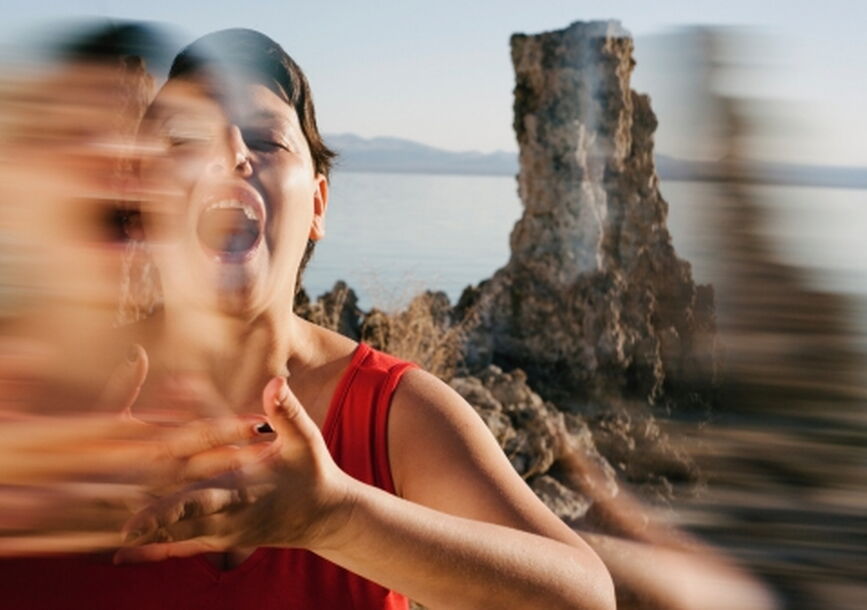 photo of a woman; double exposed photo in front of a rock monument