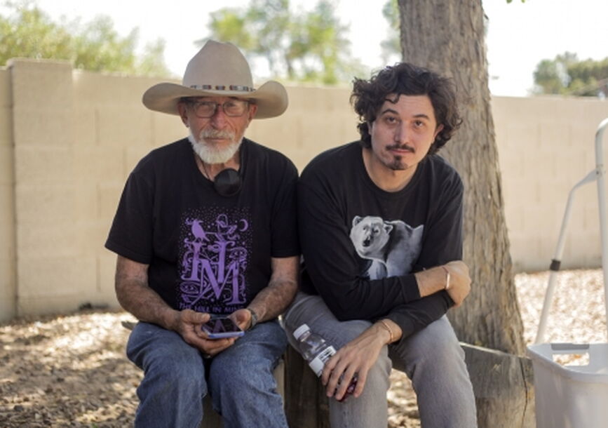 2 men sitting on a tree bench