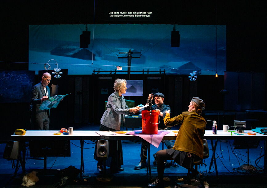 Four people gather around a table.