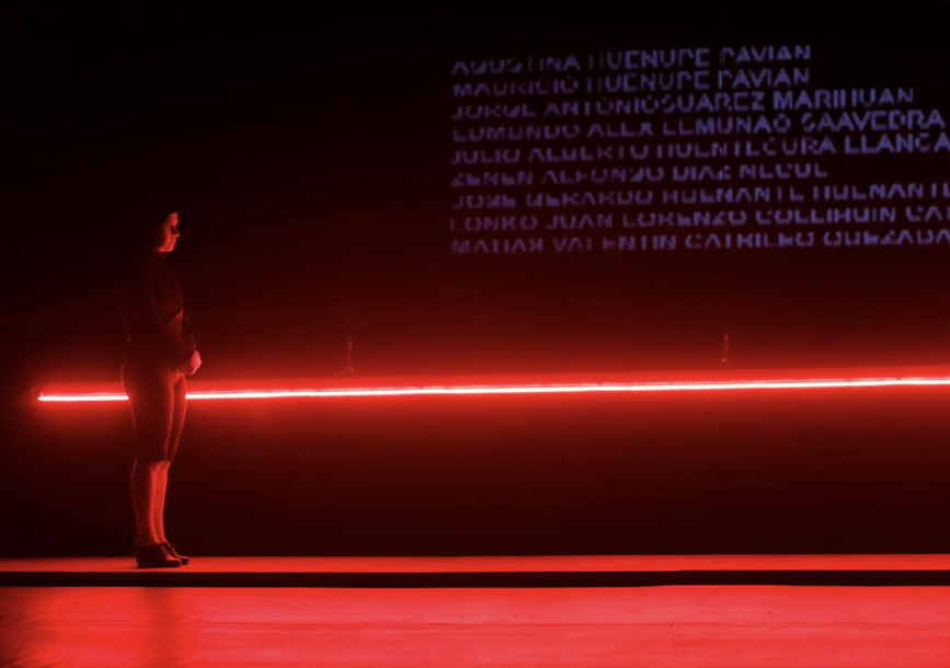 A person stands in front of a red light.