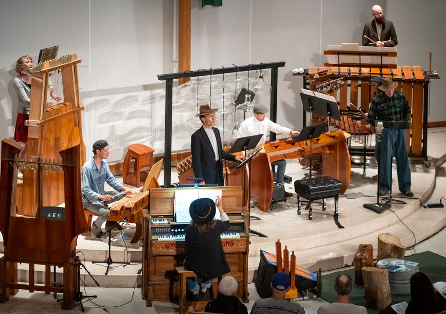 People play instruments on a stage.