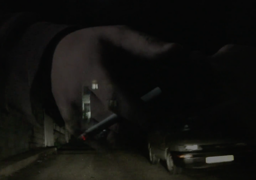 A hand vanishes over a car.