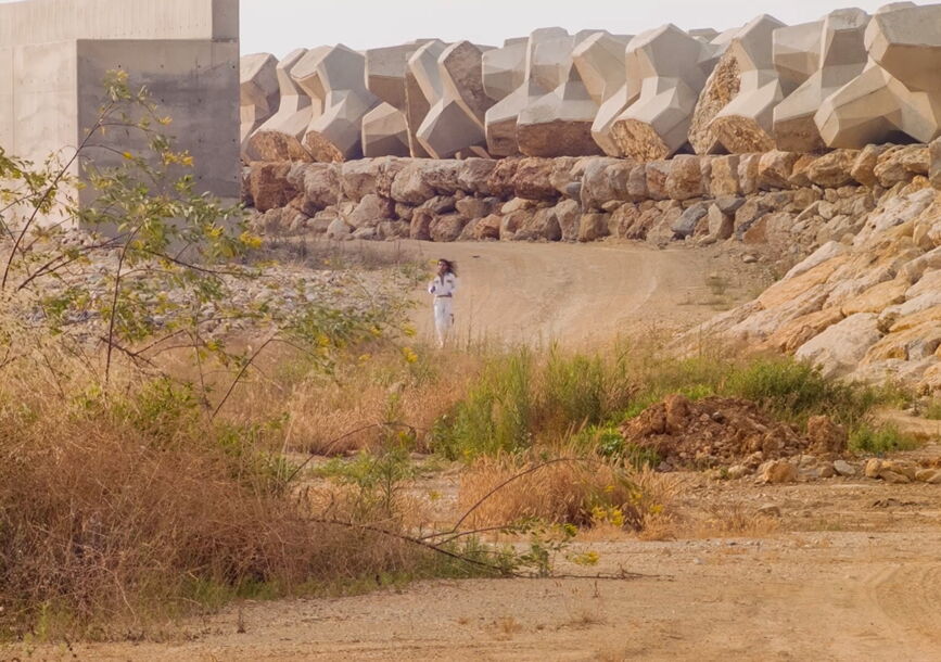 A person runs in the middle of a desert.