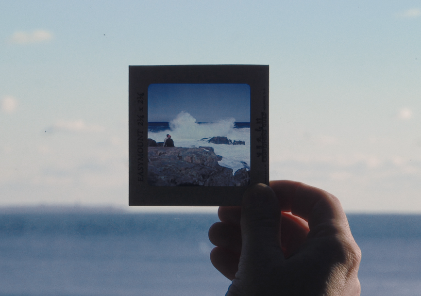 A hand holds a square photo.