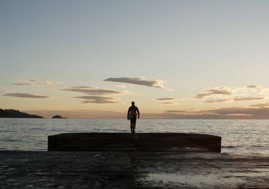 A person stands in front of the ocean.