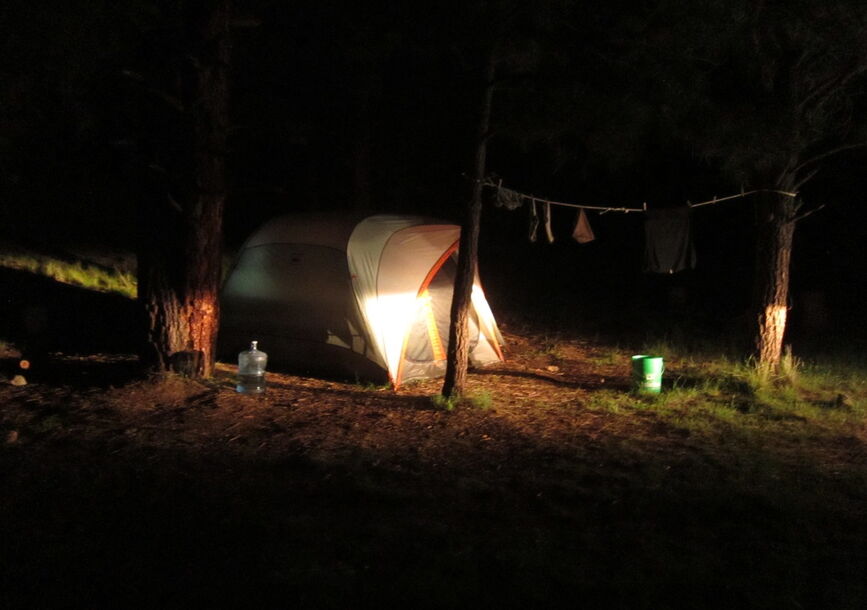 A tent is illuminated by light at night.