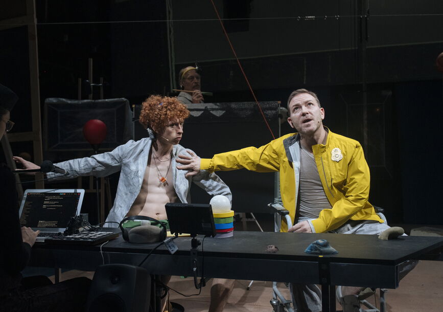 Two people sit in front of a table.