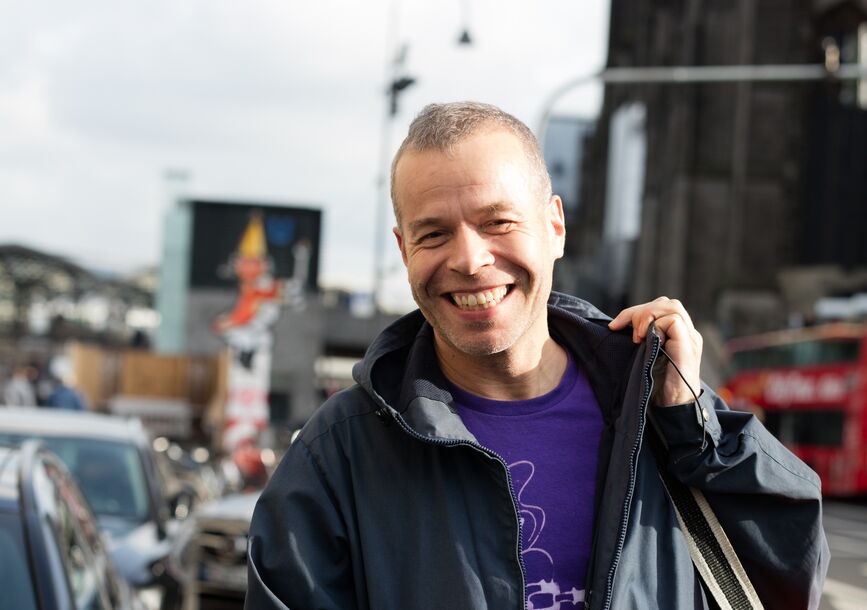 smiling man holding an orange bag