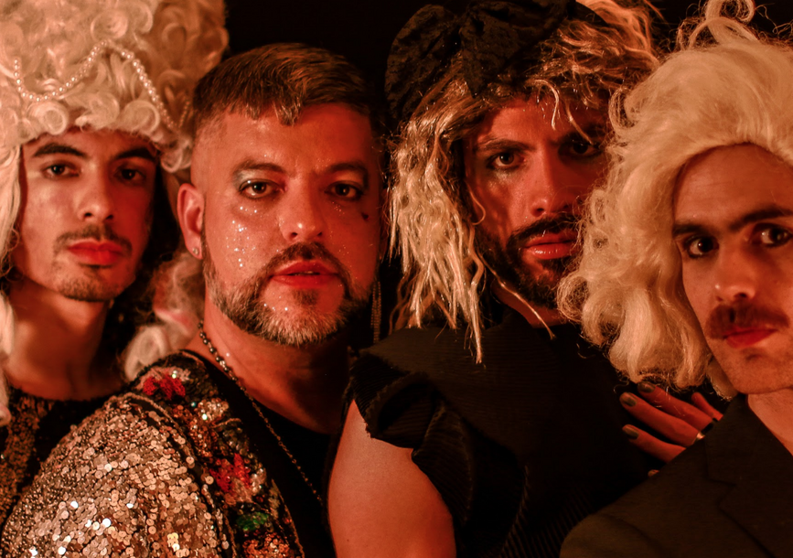 4 men dressed in drag staring at the camera together