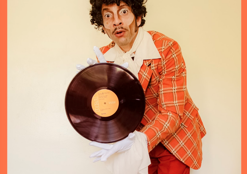 man in orange suit holds a record