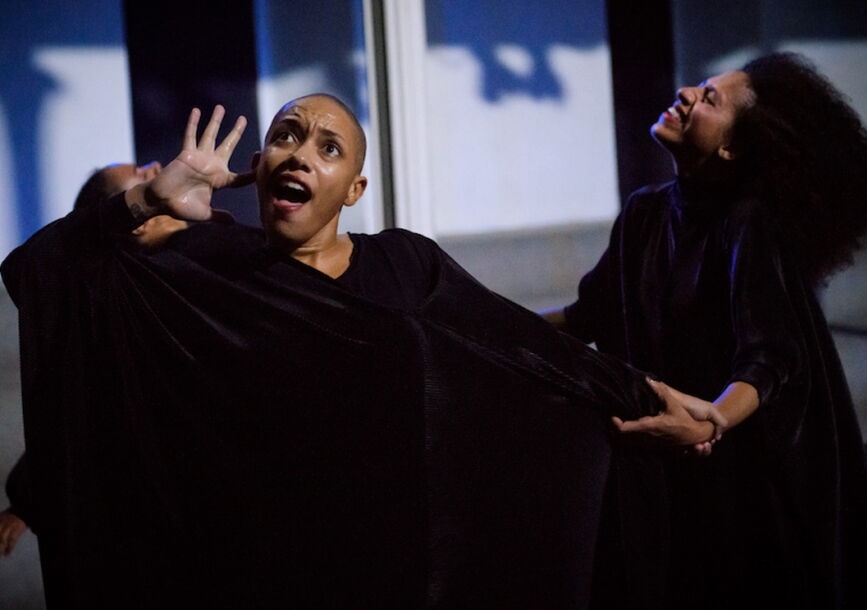two actors on stage wearing black wardrobe