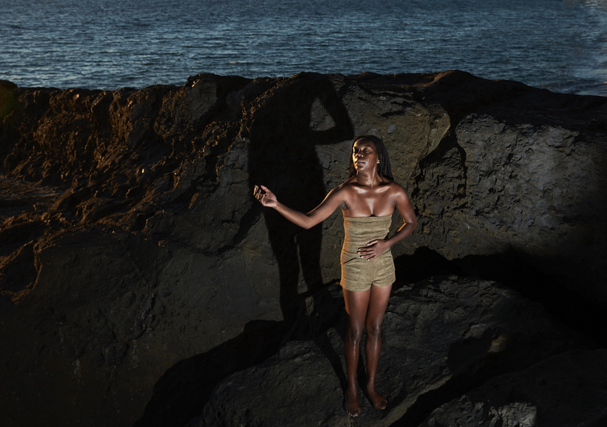 woman standing on rocks by ocean