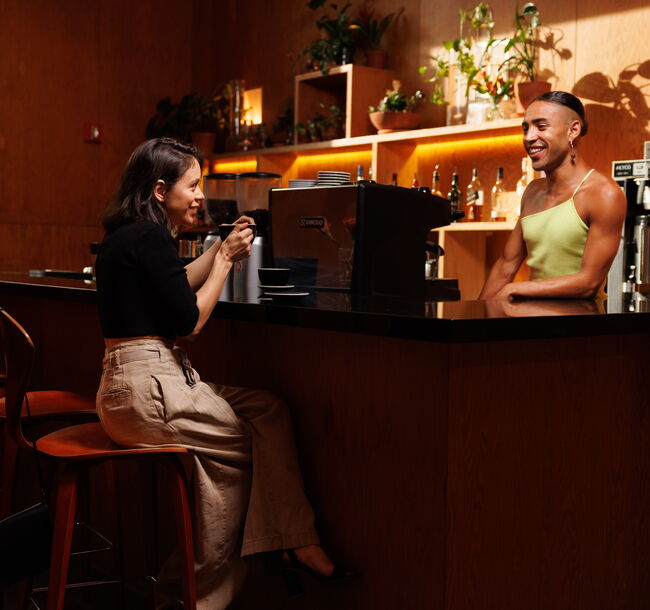 Two people have conversation over espresso machine at REDCAT bar