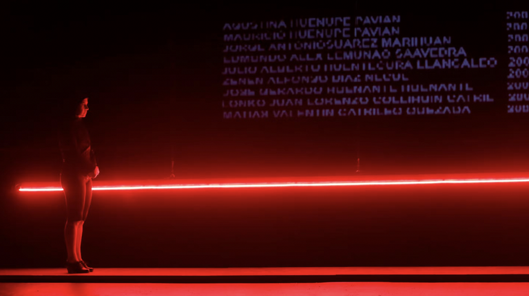 A person stands in front of a red light.