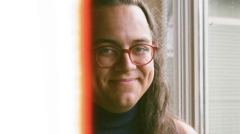 inti smiles in front of a window.