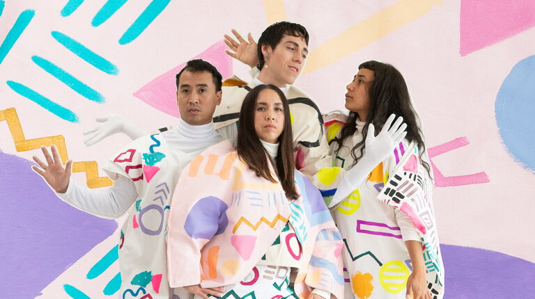 Four people posing with colorful and geometric costumes.
