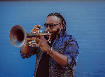 A man blowing into a trumpet.