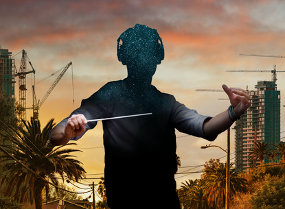 A faceless person holding a conductor's baton and wearing headphones surrounded by a cityscape.