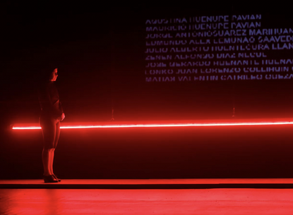 A person stands in front of a red light.