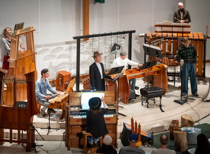 People play instruments on a stage.