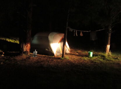 A tent is illuminated by light at night.