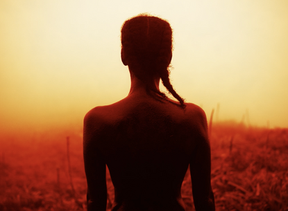 The back of a person in front of a landscape.