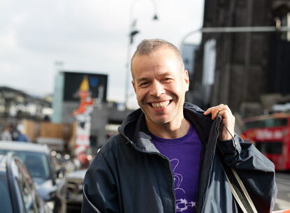 smiling man holding an orange bag