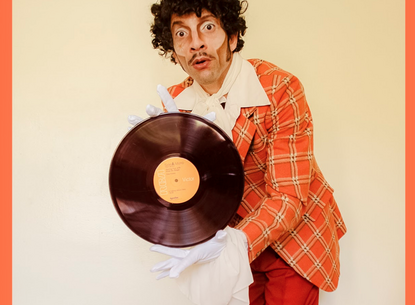man in orange suit holds a record