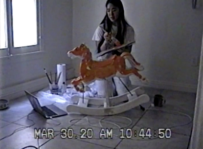 woman painting a rocking horse toy
