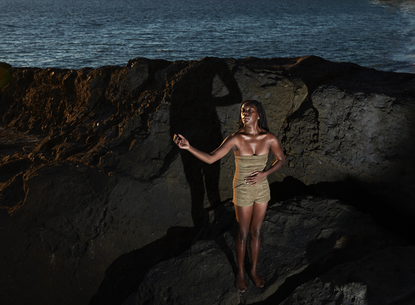 woman standing on rocks by ocean